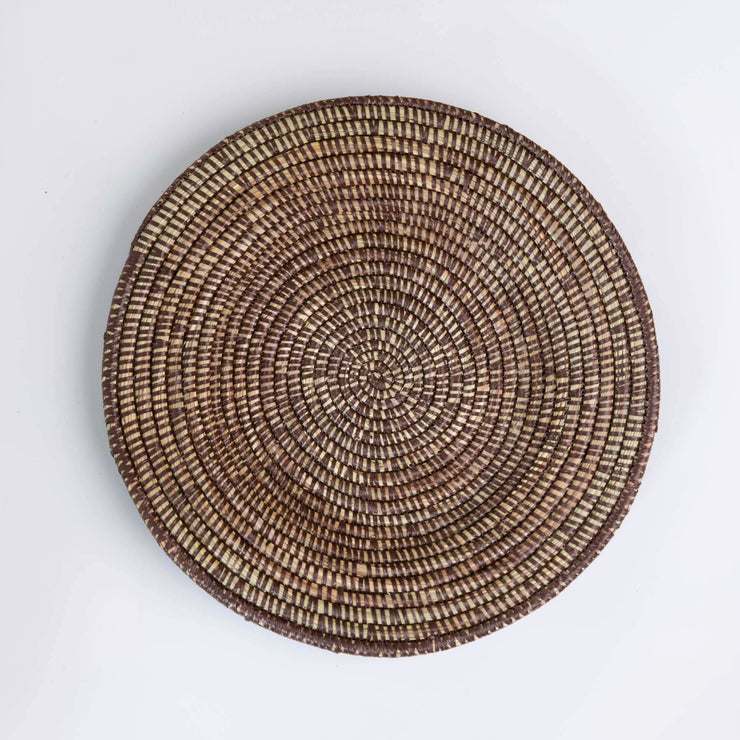a handwoven curved lap tray by la basketry woven from dried grasses and recycled plastic strings in black 