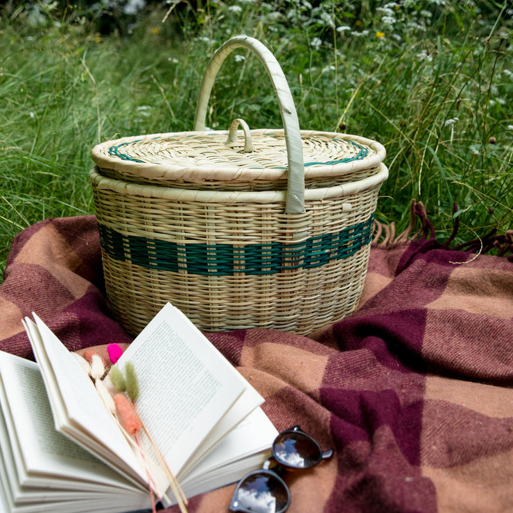 la basketry green handwoven picnic basket on tartan blanket surrounded by grass