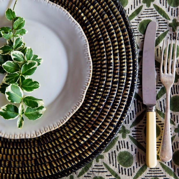 handwoven curved lap tray in black by la basketry set on a botanical tablecloth