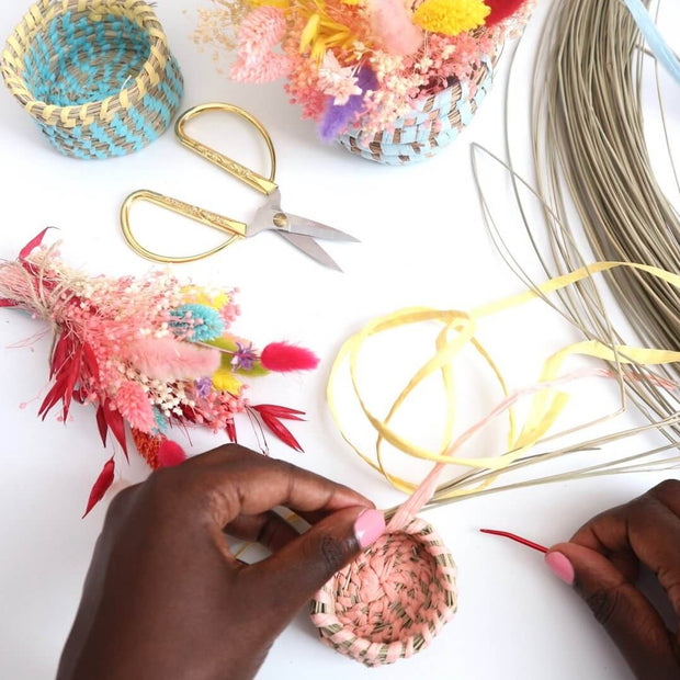 a miniature woven basket being handmade in progress from the mini basket kit from la basketry, shown in pink